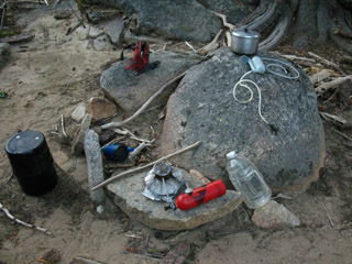 Campsite featuring perfect rock chair with all necessary gear arrayed within reach.